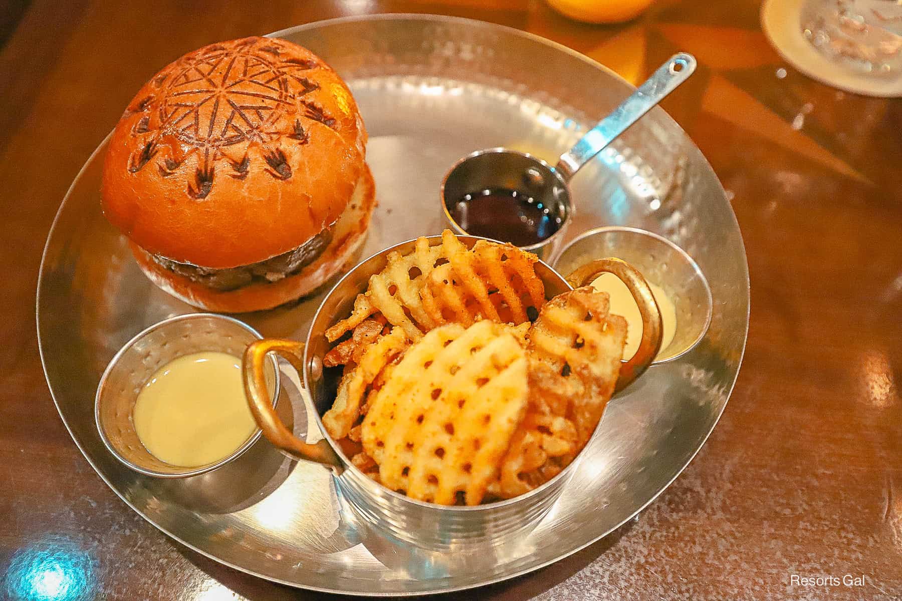 a platter with a burger, fries and sauces 