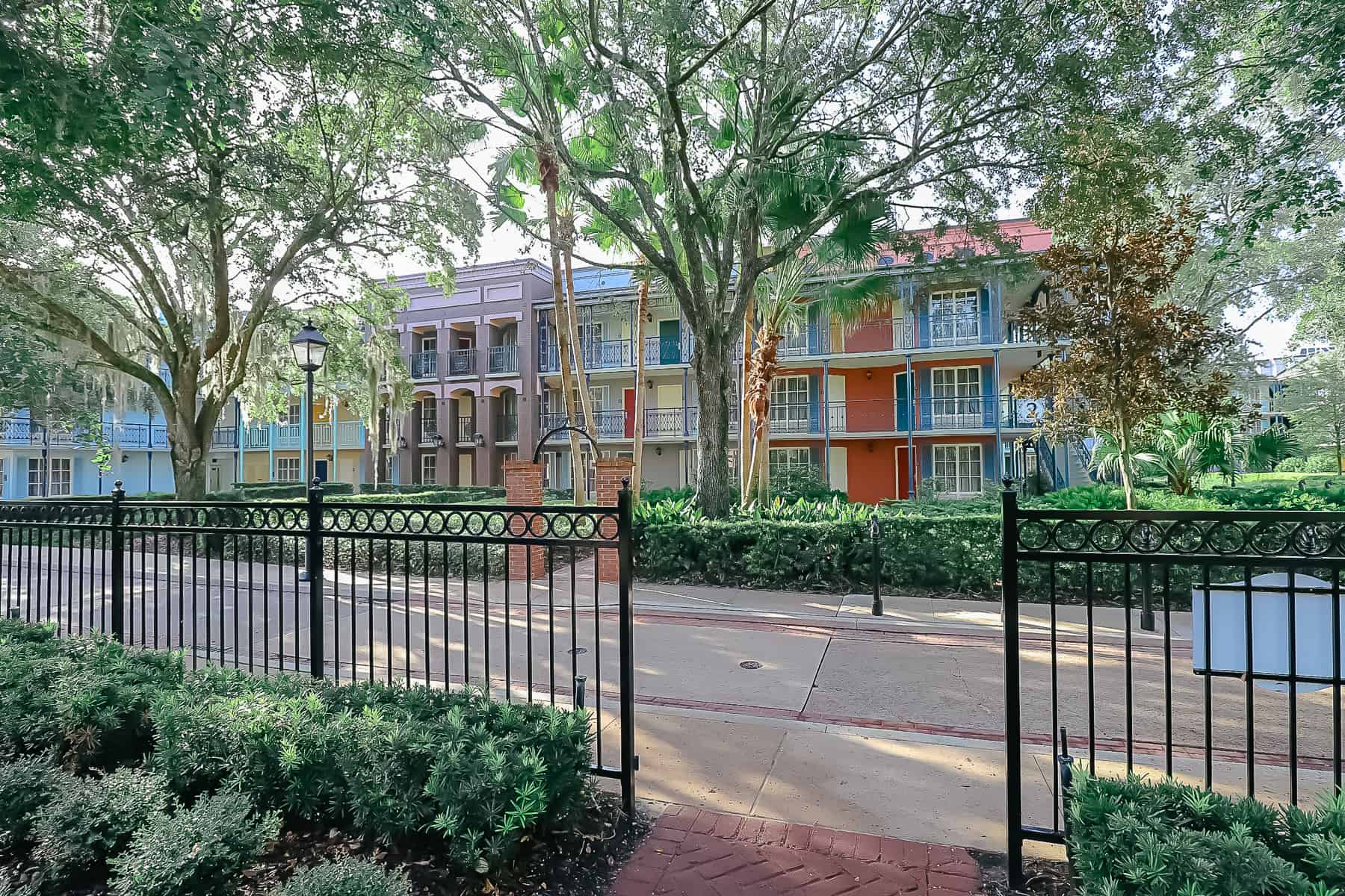 The immaculate landscaping of Port Orleans French Quarter with bright color buildings in the backdrop. 