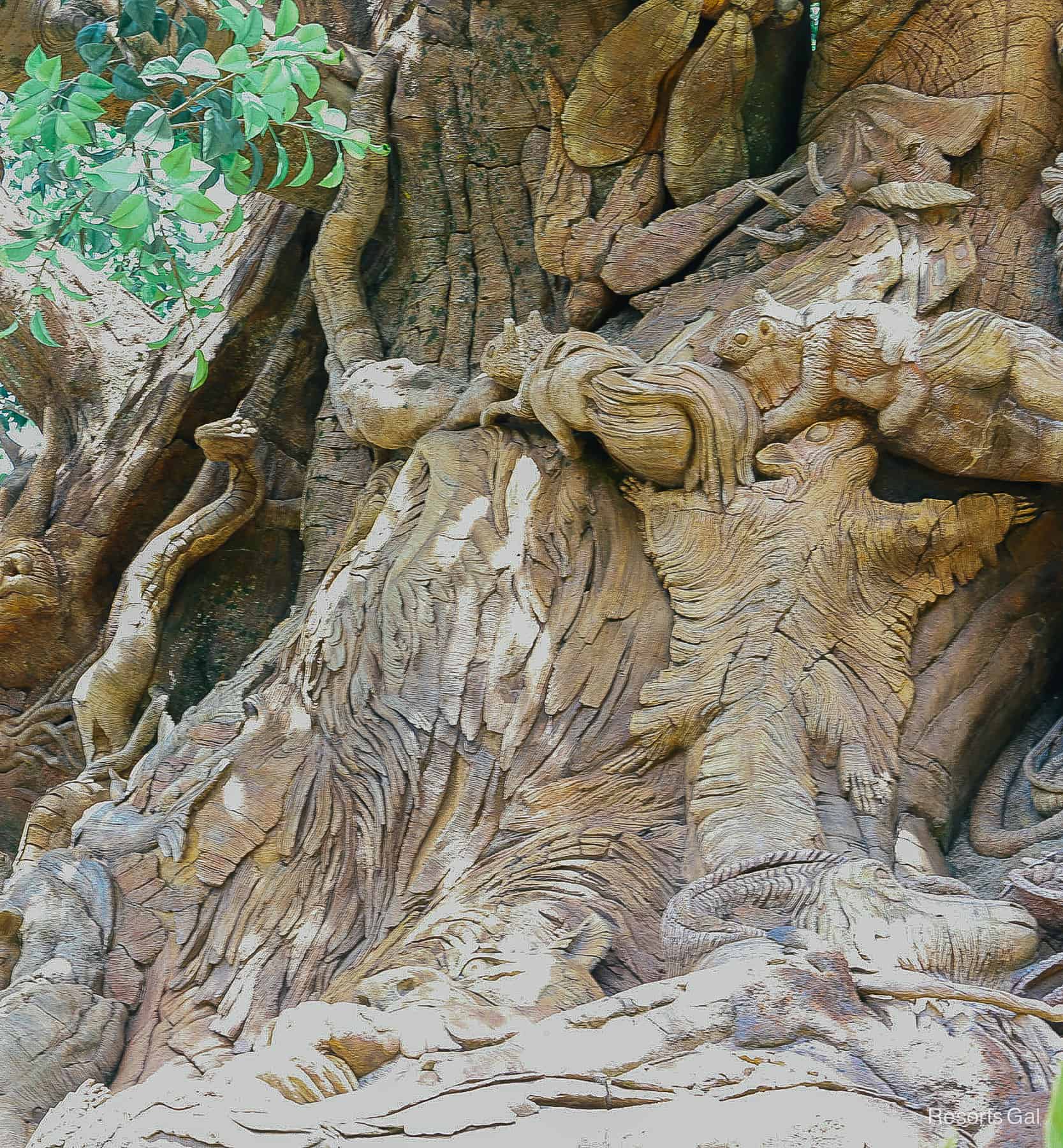 a closeup of several animal carvings on the tree of Life including a snake and a flying squirrel