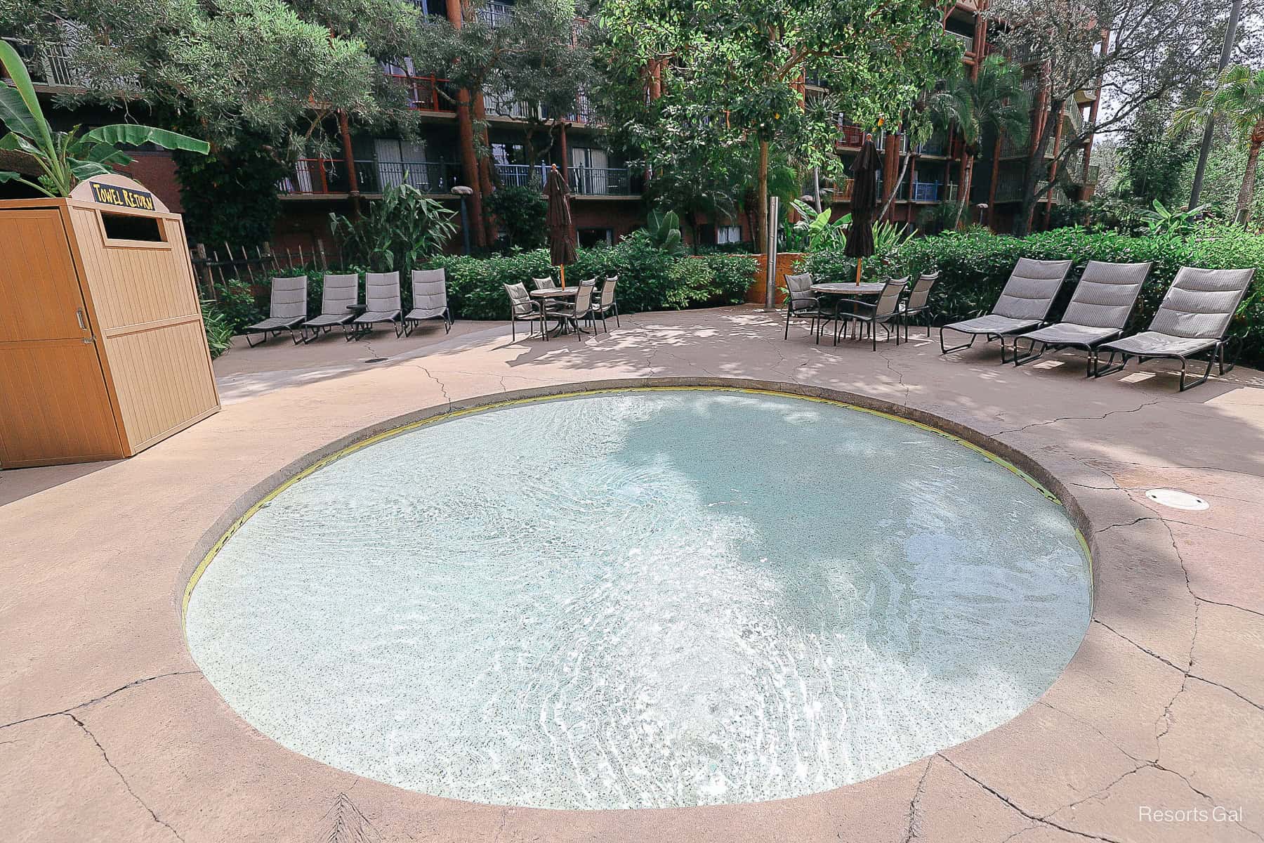 a kiddie pool with lounge chairs surrounding it