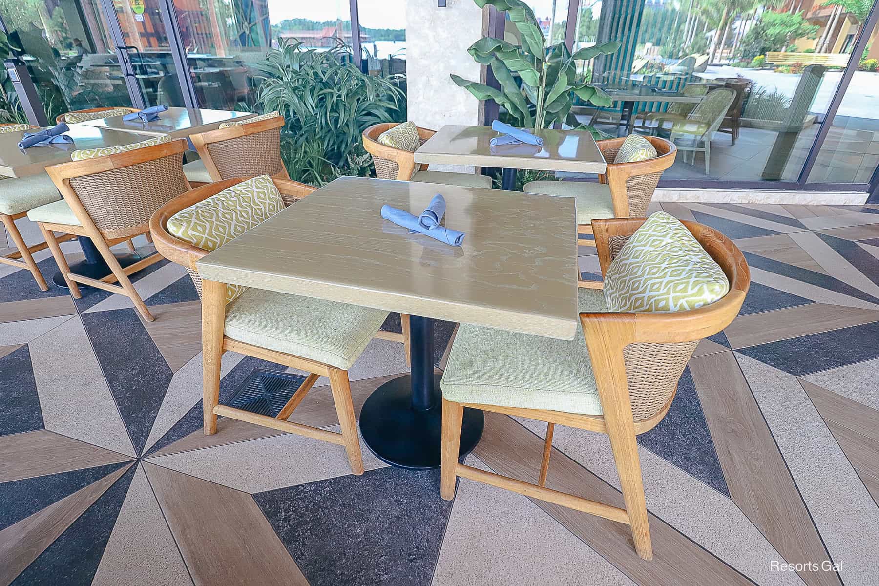 an empty table and chairs in the outdoor dining area 