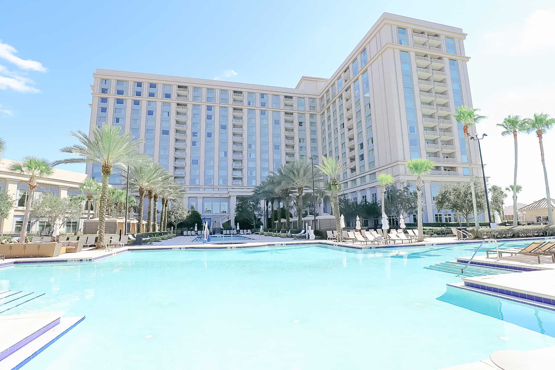 a view of the hotel with the swimming pool in front of it 