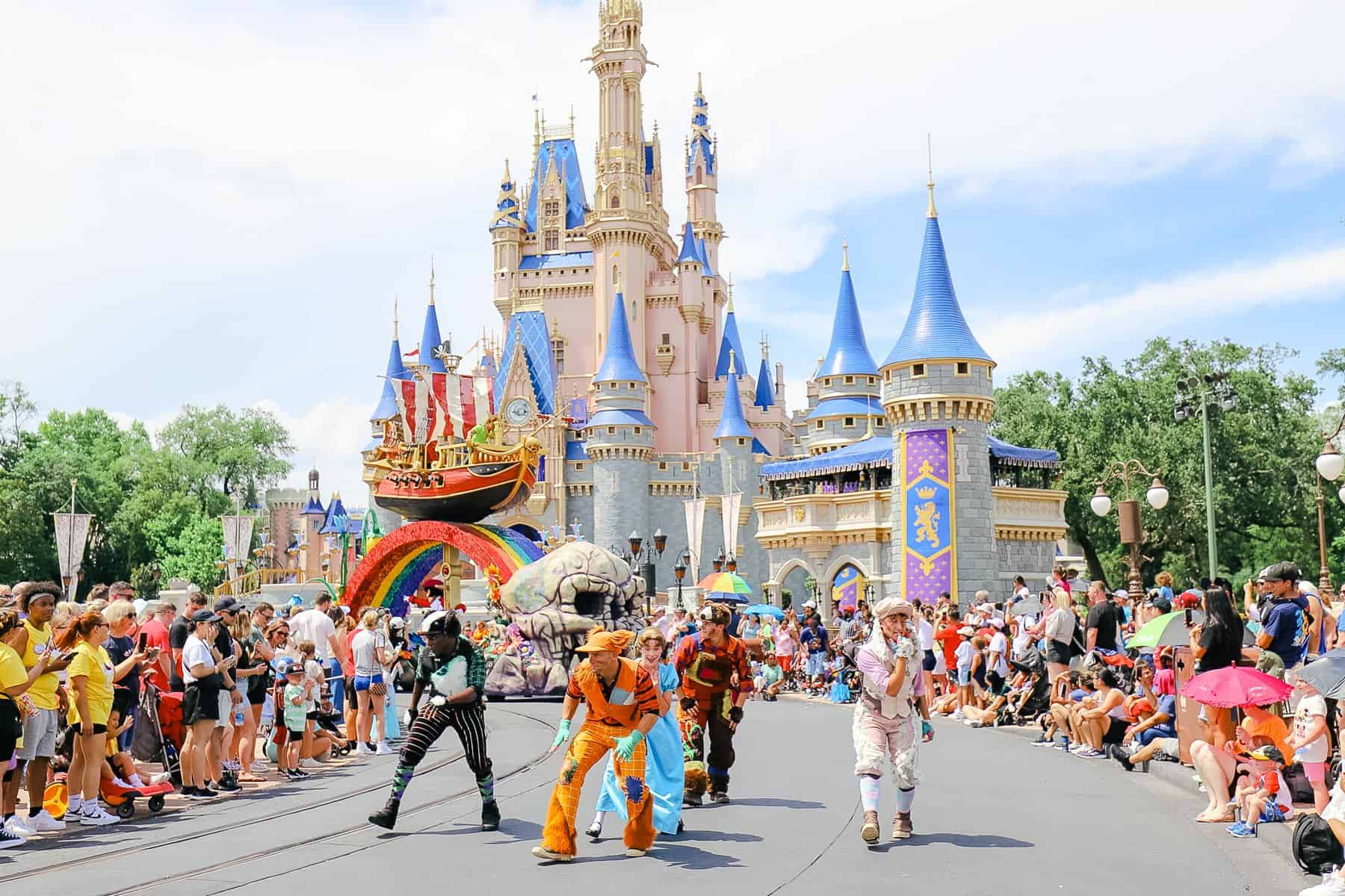 A group of parade performers passing Cinderella Castle. 