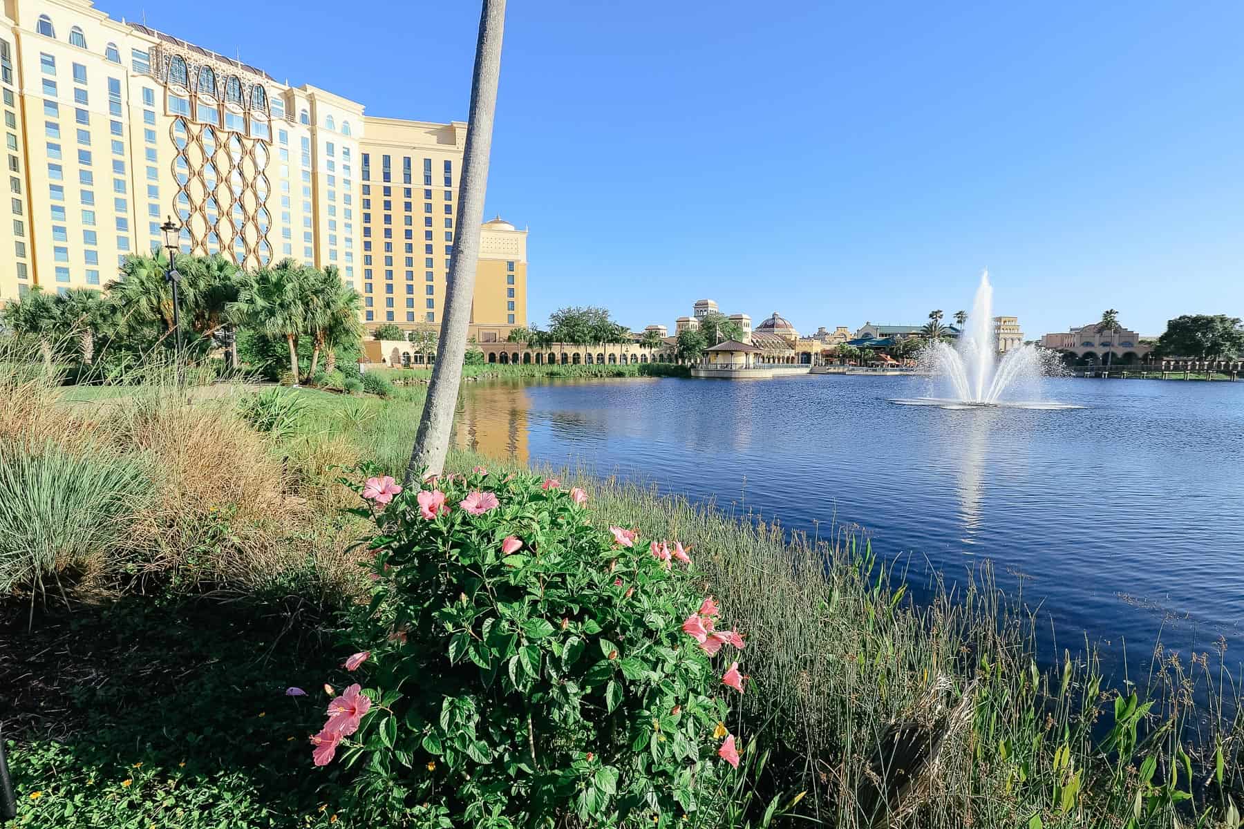 A water feature in the center of the lake with a hotel in the backdrop. 