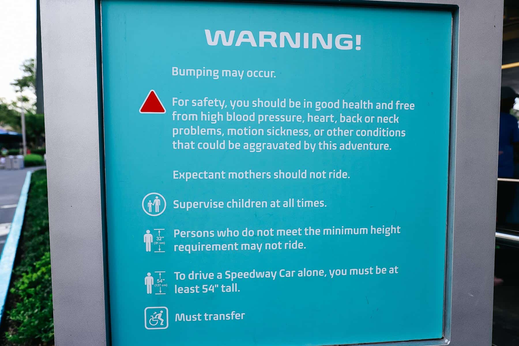 Warning side at the ride's entrance that lists items to consider before riding the Speedway. 