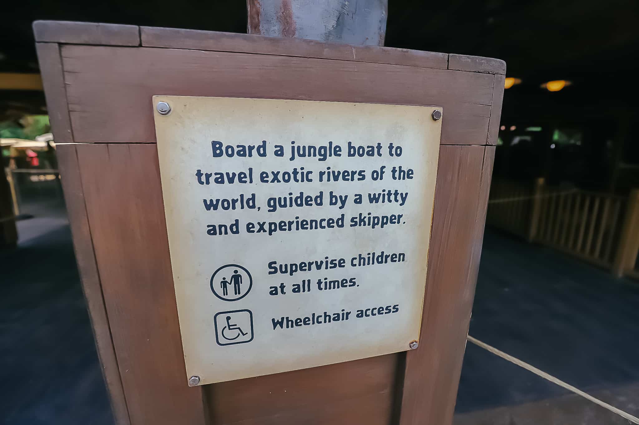 Sign reads, "board a jungle boat to travel exotic rivers of the world, guided by a witty and experienced skipper. Supervise children at all times. Wheelchair access