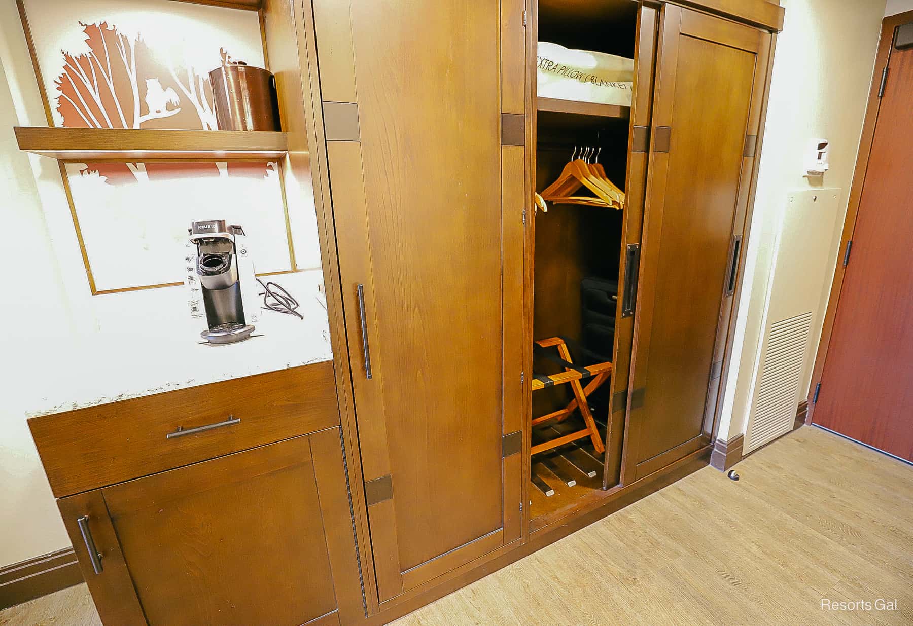 a closet with a folding door and a luggage rack 