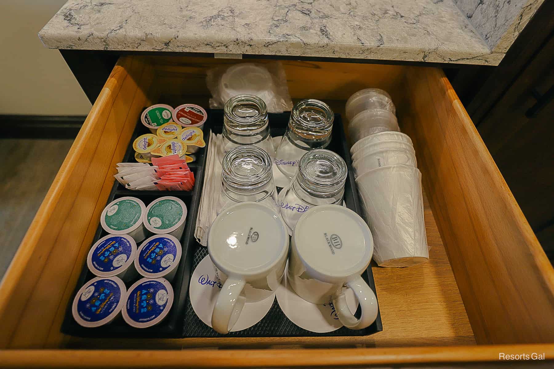 a drawer opens to reveal glasses and coffee cups 