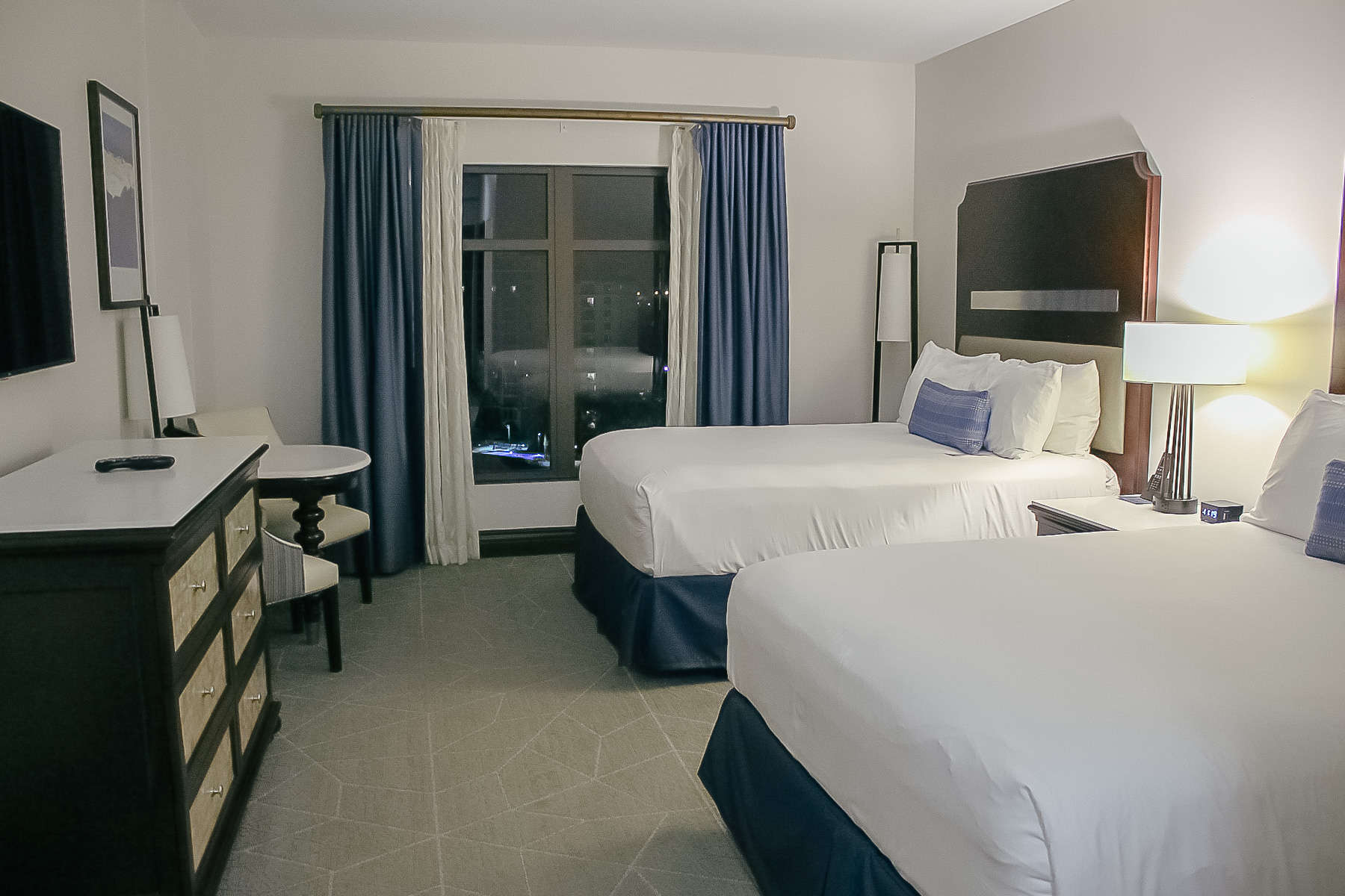 Two queen beds with blue accent pillows in hotel room at Wyndham Grand Orlando Bonnet Creek. 