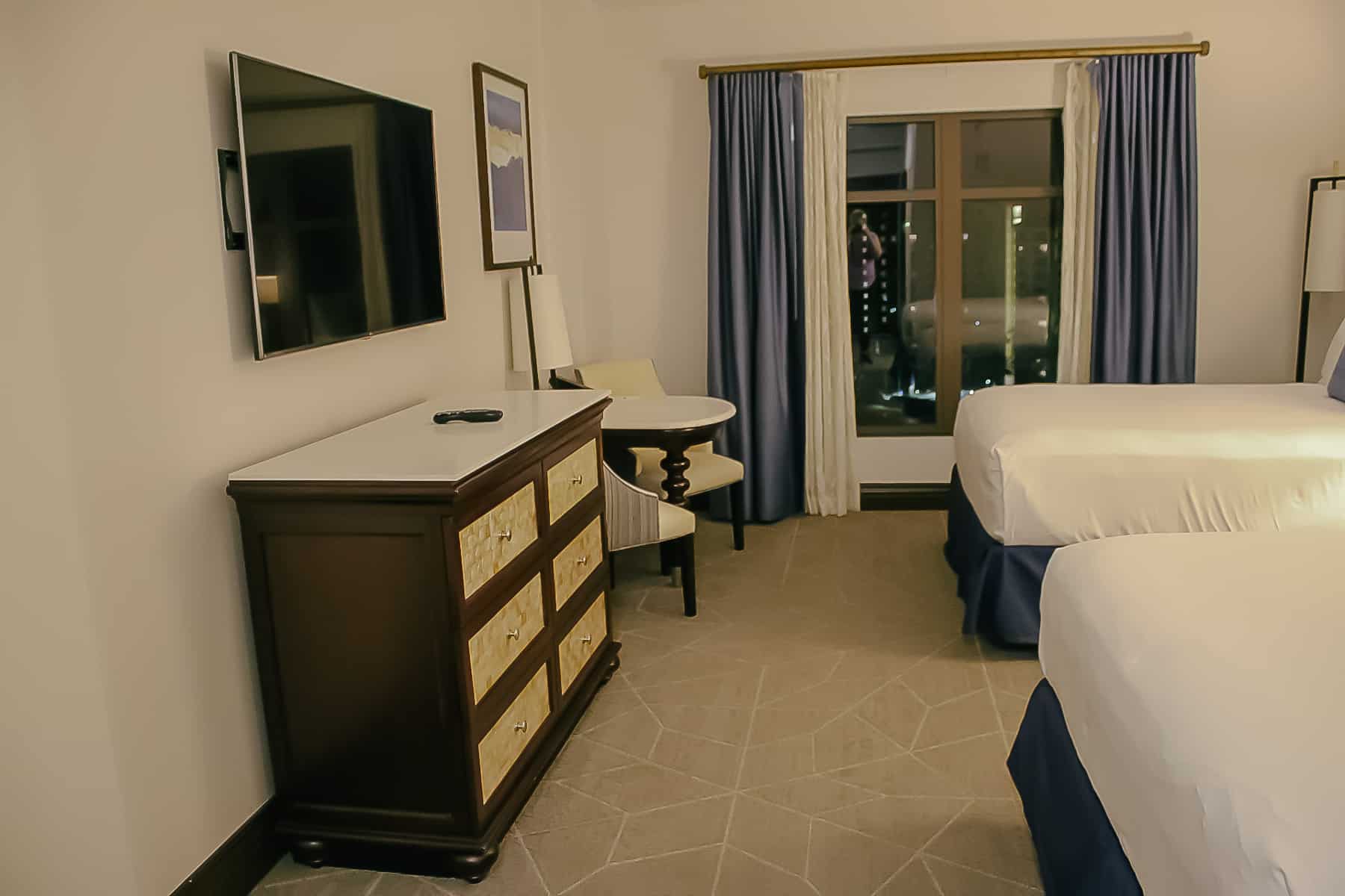 a dresser with storage drawers and a flat screen television on the wall 